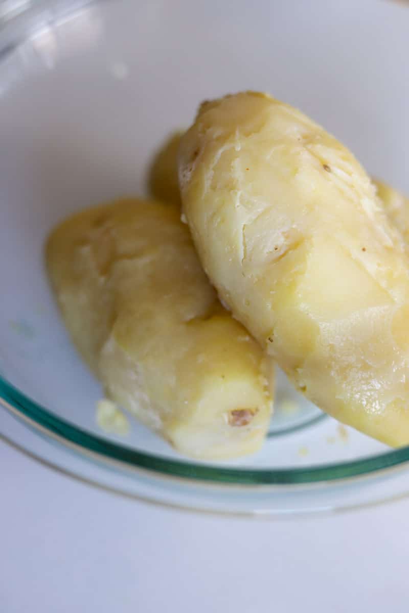 peeled potatoes in a clear mixing bowl