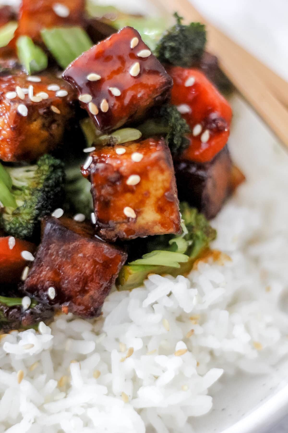tofu stir fry garnished with sesame seeds served over rice