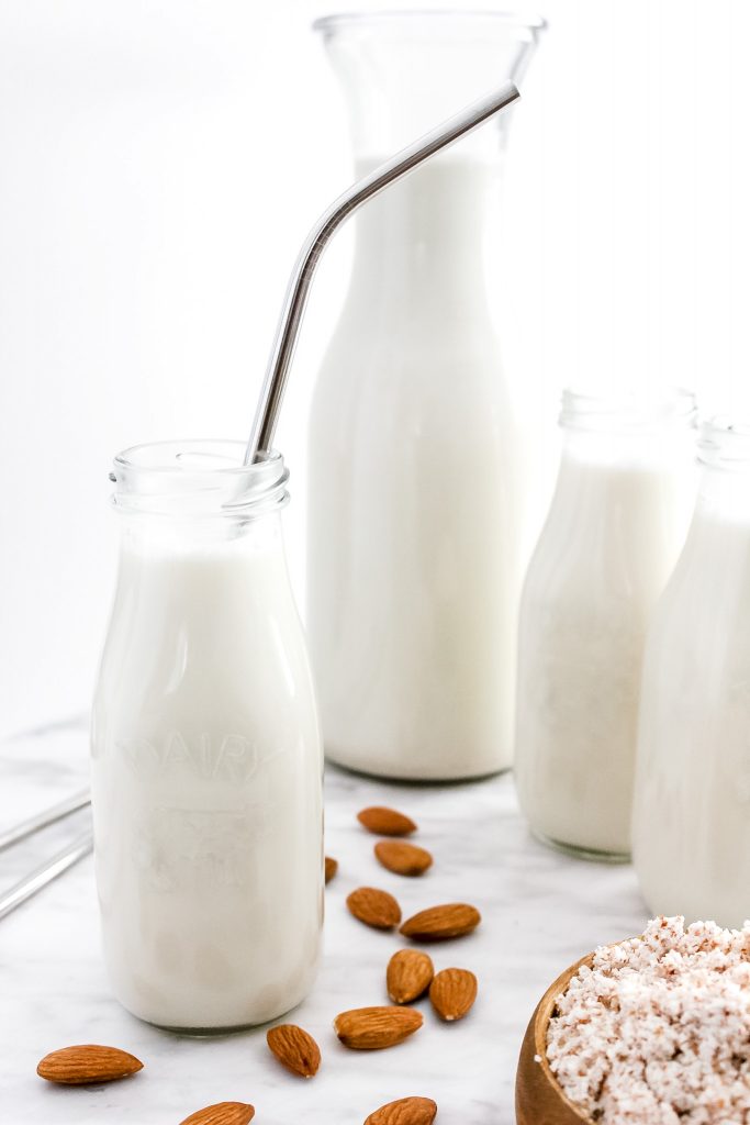 How to Make the BEST Almond Milk (Dairy-Free & Vegan)_Featured Image_in Small Glass Jugs