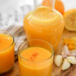 Immunity and Energy Boosting Drink in two glasses and a pitcher on wooden board