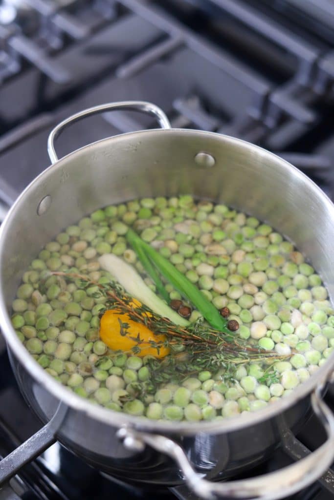 gungo peas in pot with fresh herbs and scotch bonnet pepper.