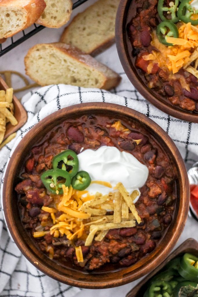 Chili in Wooden Bowls with Sour Cream, Cheddar Cheese, Jalapenos and Tortilla Strips