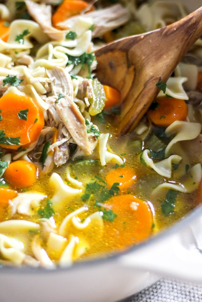 Homestyle Chicken Noodle Soup in Large Pot with Wooden Spoon
