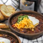 Slow Cooker Chili in 2 Bowls with Slow Cooker in Back