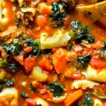 Hearty Tortellini Soup in Stockpot with lots of kale, tomatoes, carrots, celery