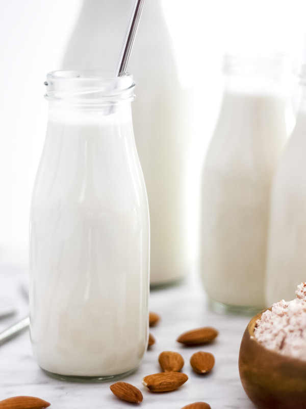 How to Make the BEST Almond Milk (Dairy-Free & Vegan)_Featured Image_in Small Glass Jugs