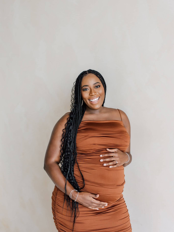 Taneisha Morris in Brown Dress Holding Belly for Maternity Shoot