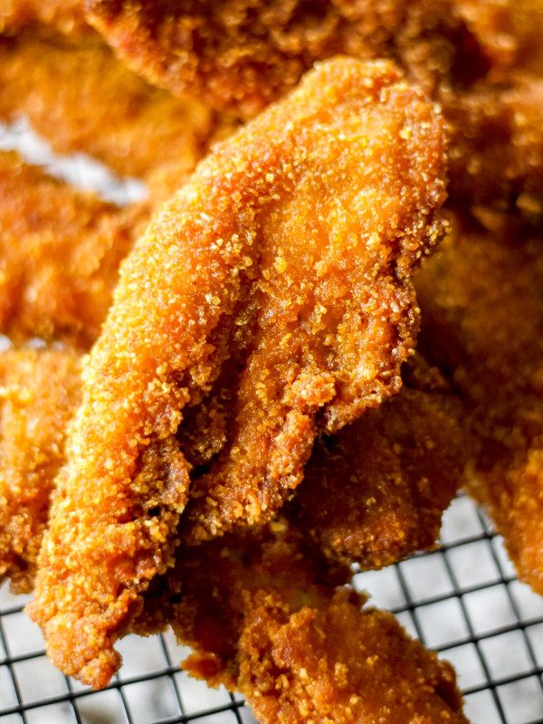 Double-Coated Cornflake Crumb Fried Chicken Strips on Black Wired Basket