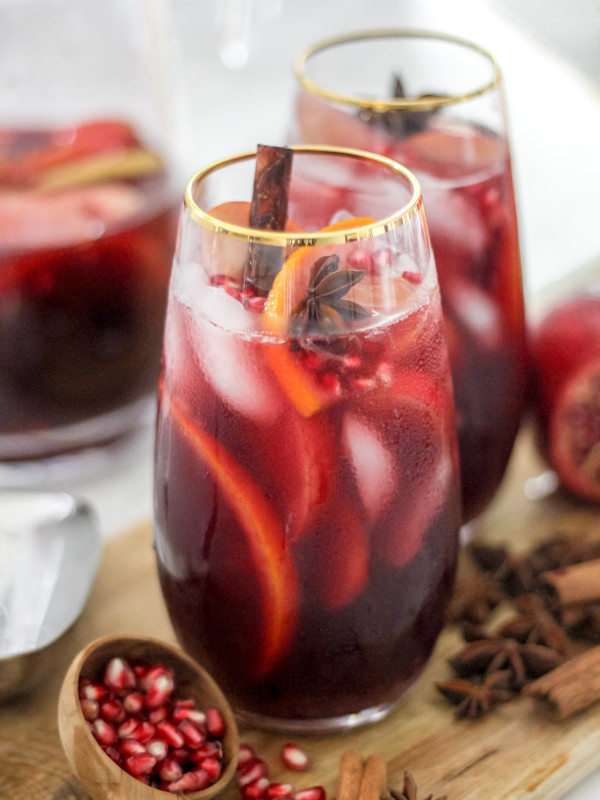 Spiced Autumn Apple Sangria in two glasses on wooden board