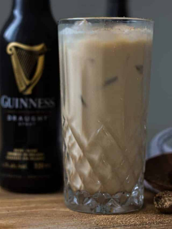 jamaican guinness punch in glass with guinness beer bottle.