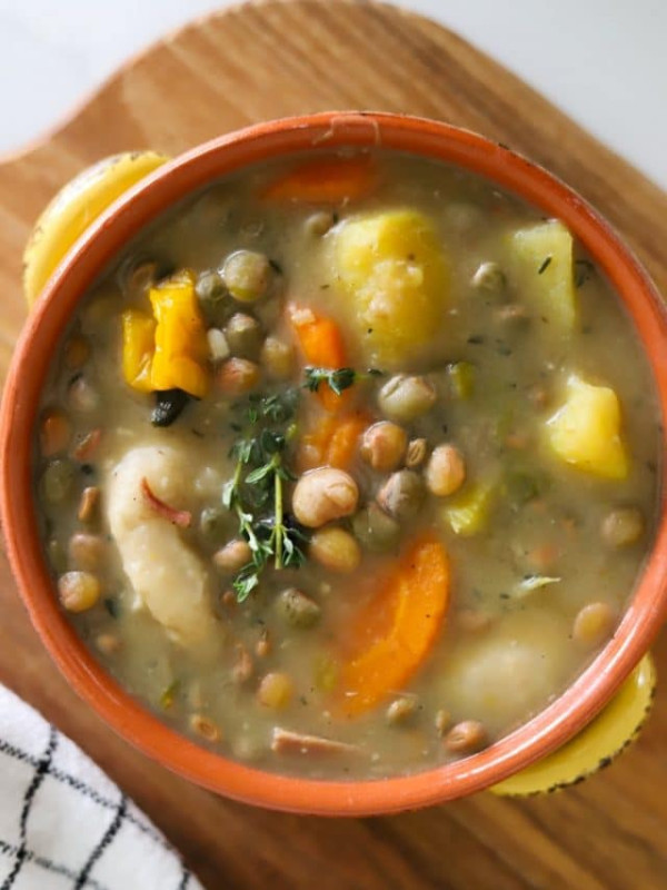 gungo peas soup in bowl with dumplings, vegetables and ground provision.