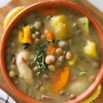 gungo peas soup in bowl with dumplings, vegetables and ground provision.