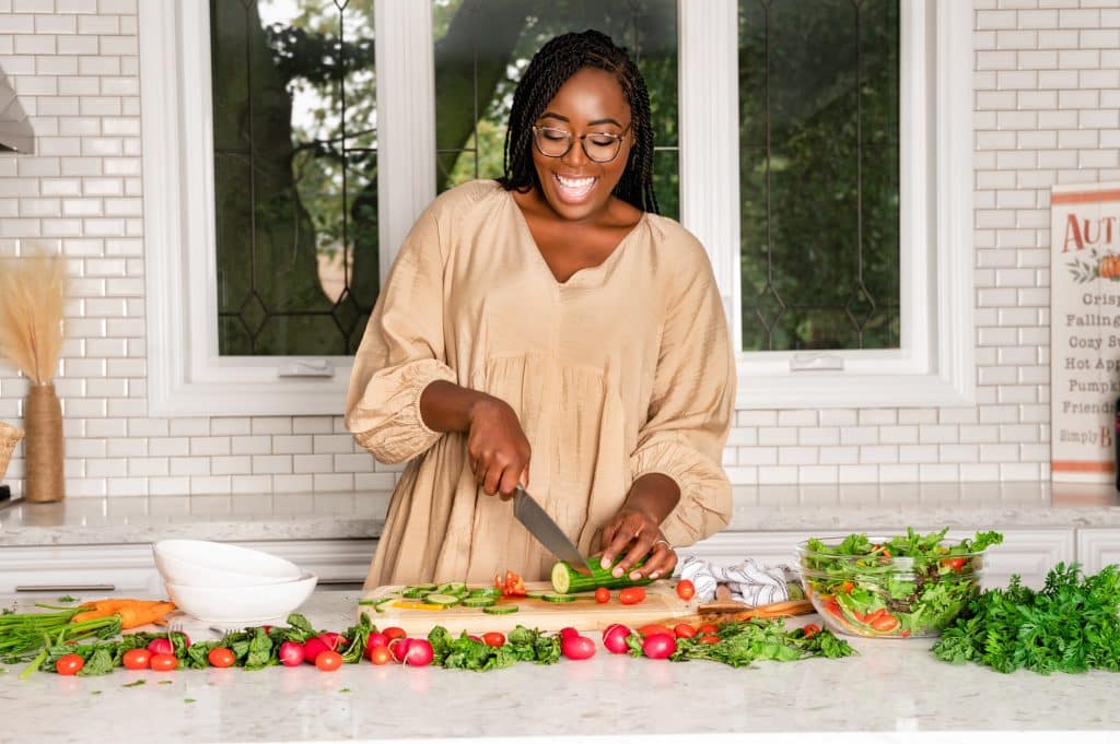 taneisha cutting up veggies in the kitchen.