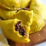 jamaican oxtail patties on wooden board.