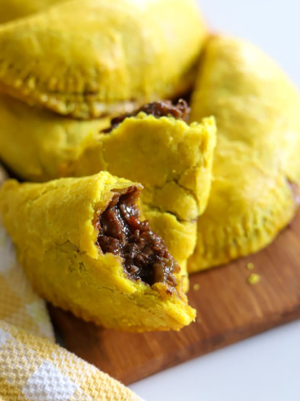 jamaican oxtail patties on wooden board.