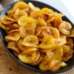 a black bowl of homemade plantain chips.