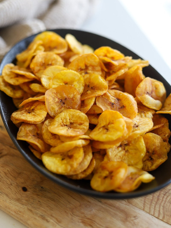 a black bowl of homemade plantain chips.