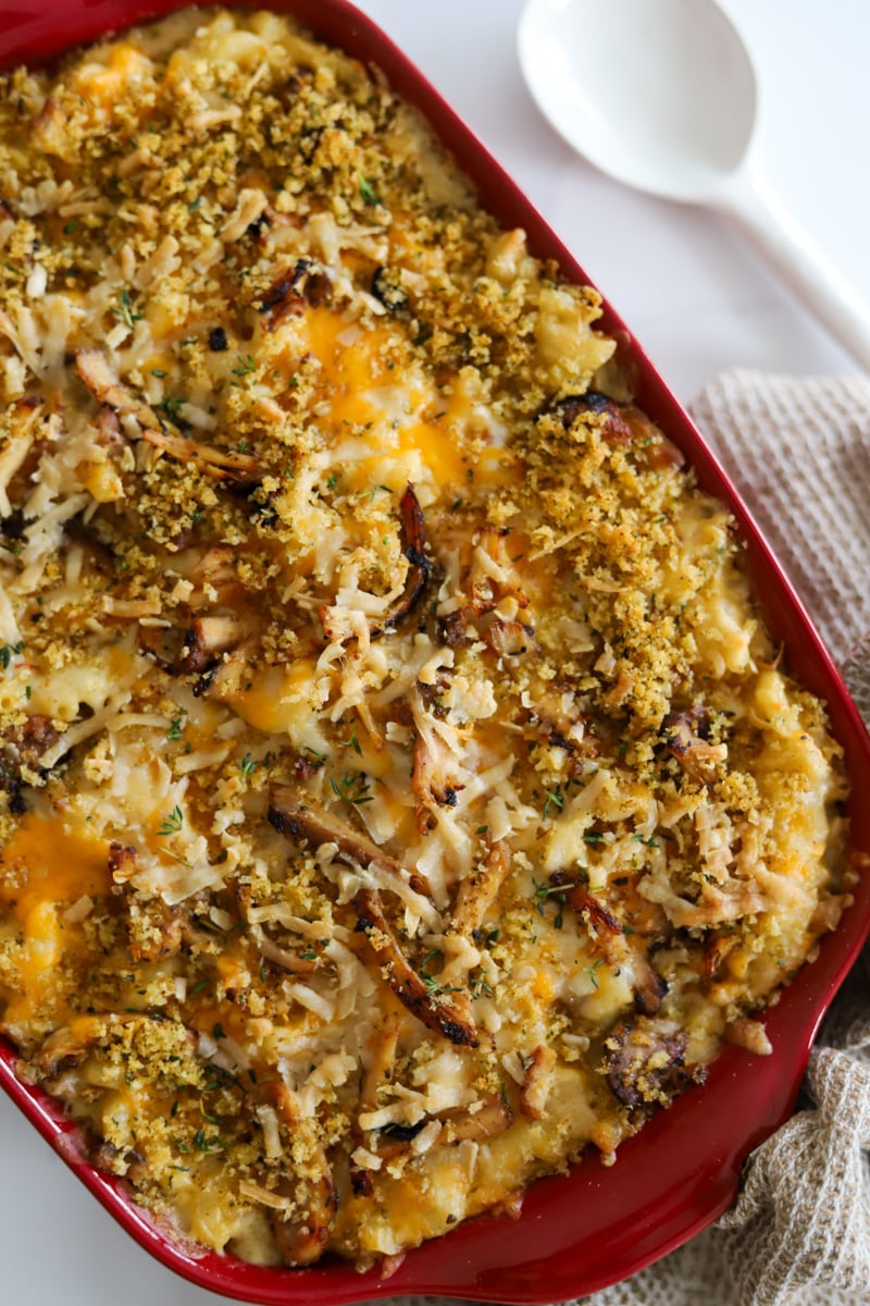 jerk chicken mac and cheese in red casserole dish.