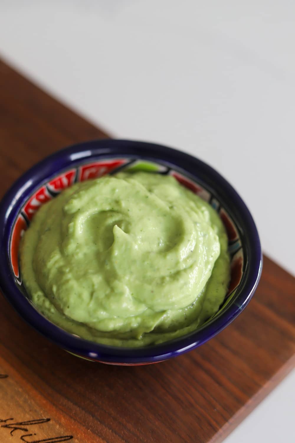 Homemade avocado crema in a bowl for Jamaican jerk chicken tacos