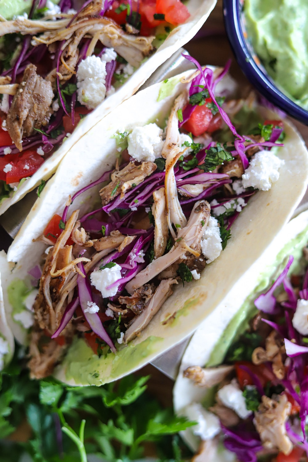 Assembled Jamaican jerk chicken tacos with avocado crema and toppings