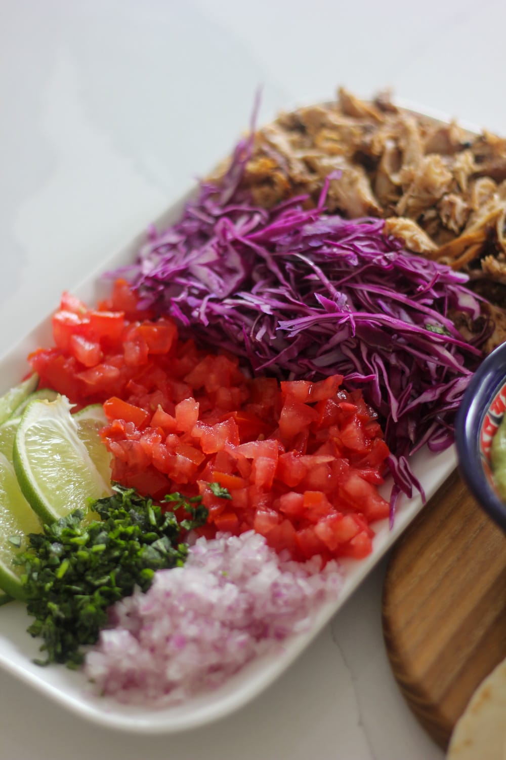Fresh toppings for Jamaican jerk chicken tacos including cabbage red onions and tomatoes