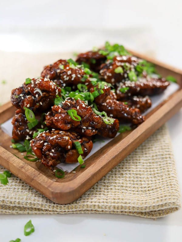 soy garlic chicken garnished with sesame seeds and green onions.