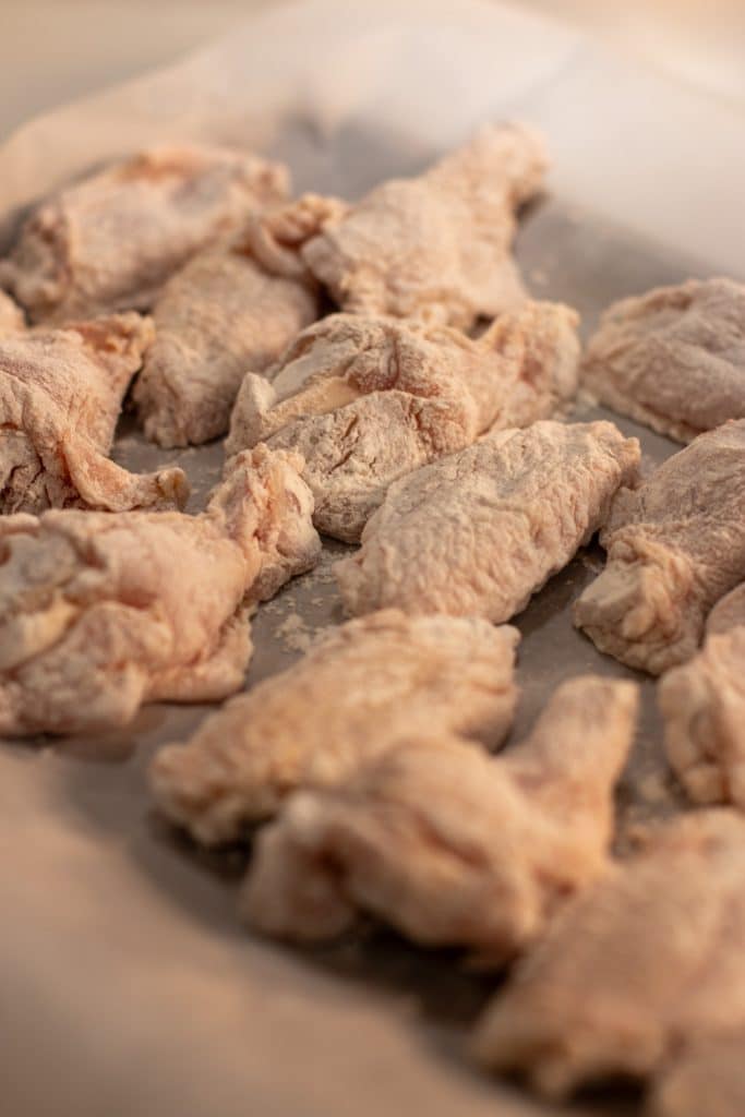 raw chicken wings dusted in flour and cornstarch.