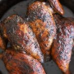 jerk spatchcock chicken in skillet.