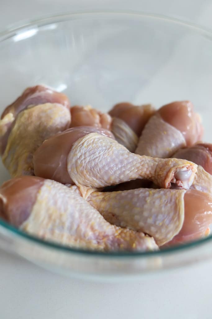 raw chicken legs in bowl.