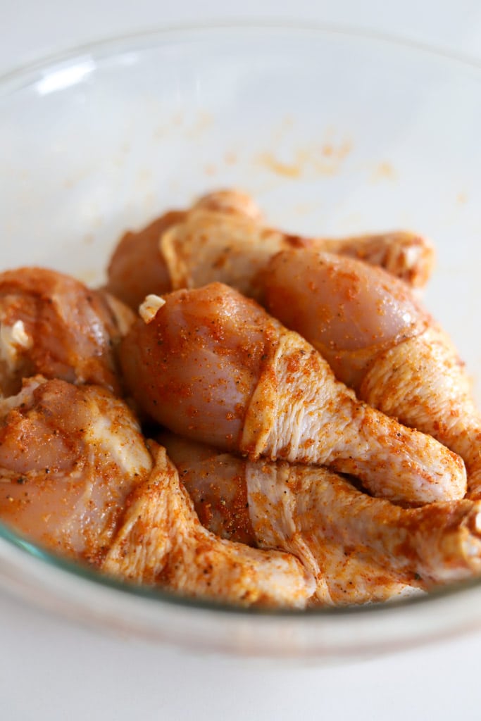 seasoned chicken legs in bowl.