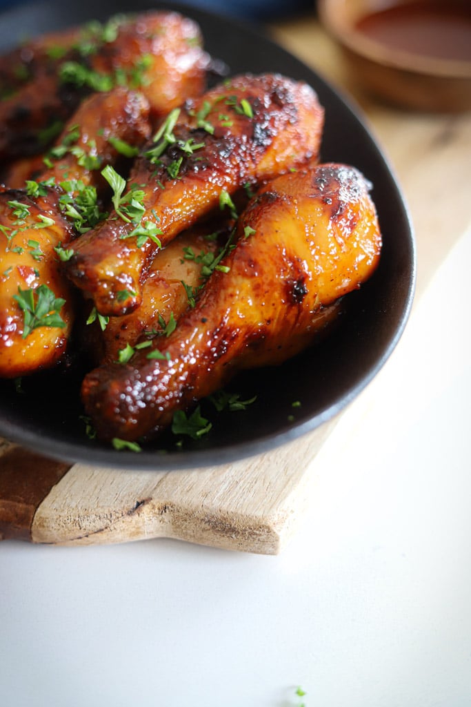 air fryer chicken legs in black plate.