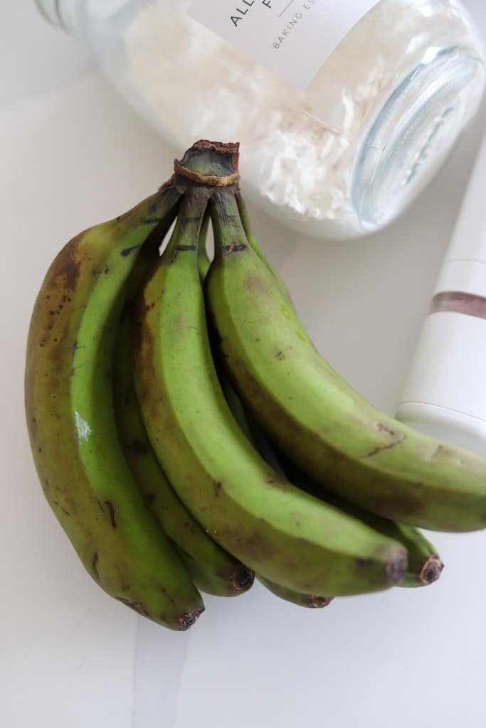 ingredients flat lay of green banana, flour and salt.