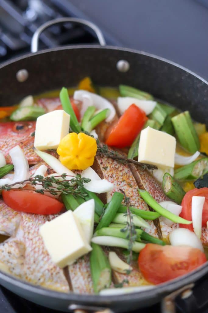 red snapper fish and ingredients in large skillet.