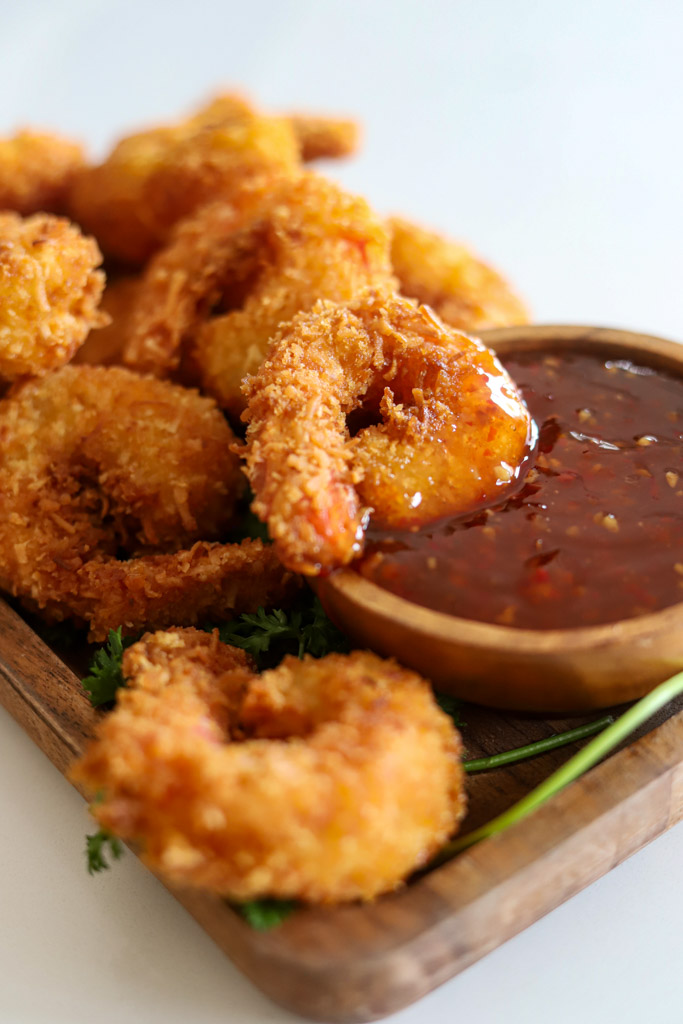 coconut shrimp dipped in sweet and sour sauce.
