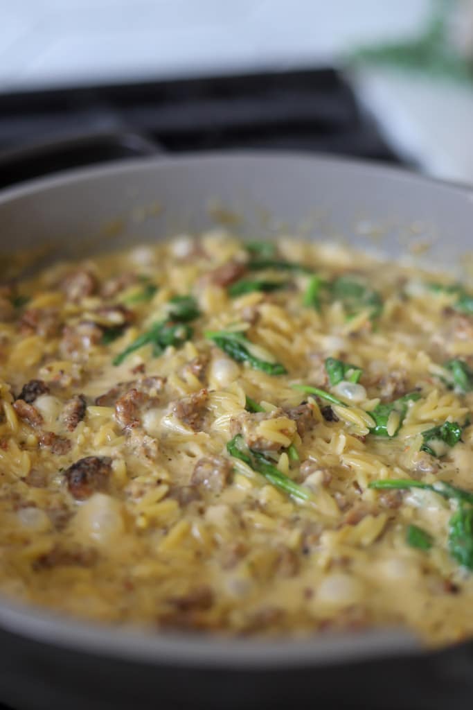 parmesan orzo simmering in skillet.