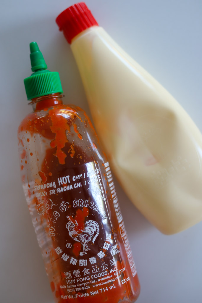 a bottle of kewpie mayo and a bottle of sriracha sauce.