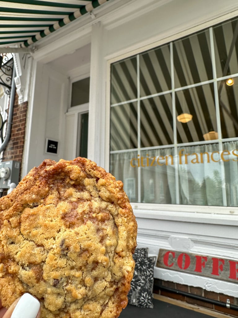holding a cookie outside of Citizen Frances in Prince Edward County