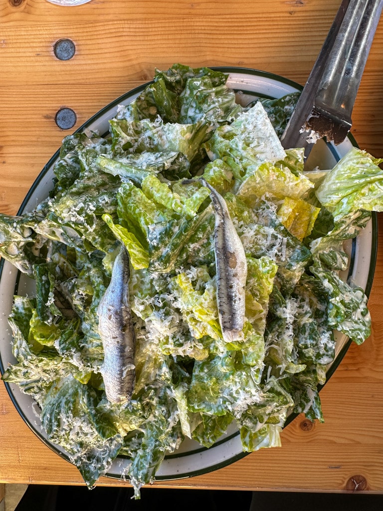 caesar salad topped with sardines