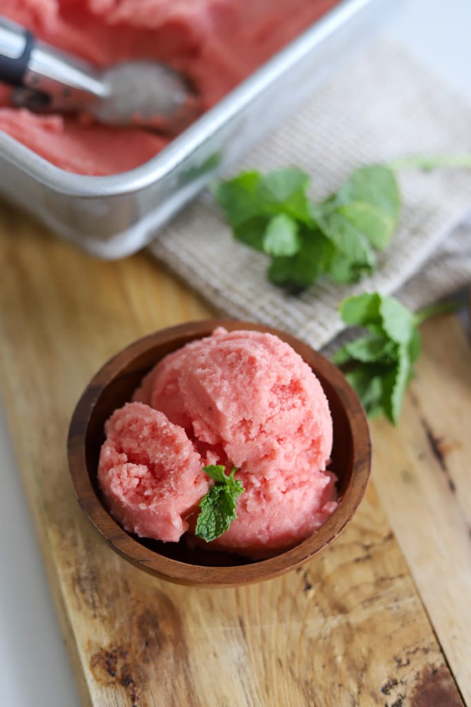 a bowl of watermelon sorbet on a cutting board
