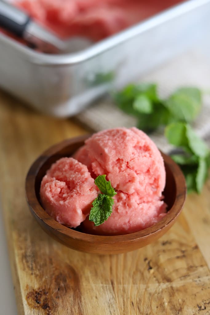 a bowl of watermelon sorbet garnished with fresh basil