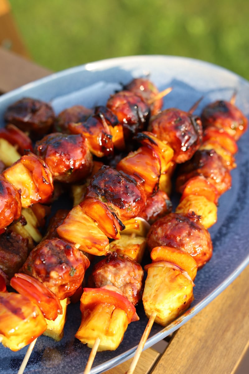 sweet and sour grilled meatballs on blue plate.