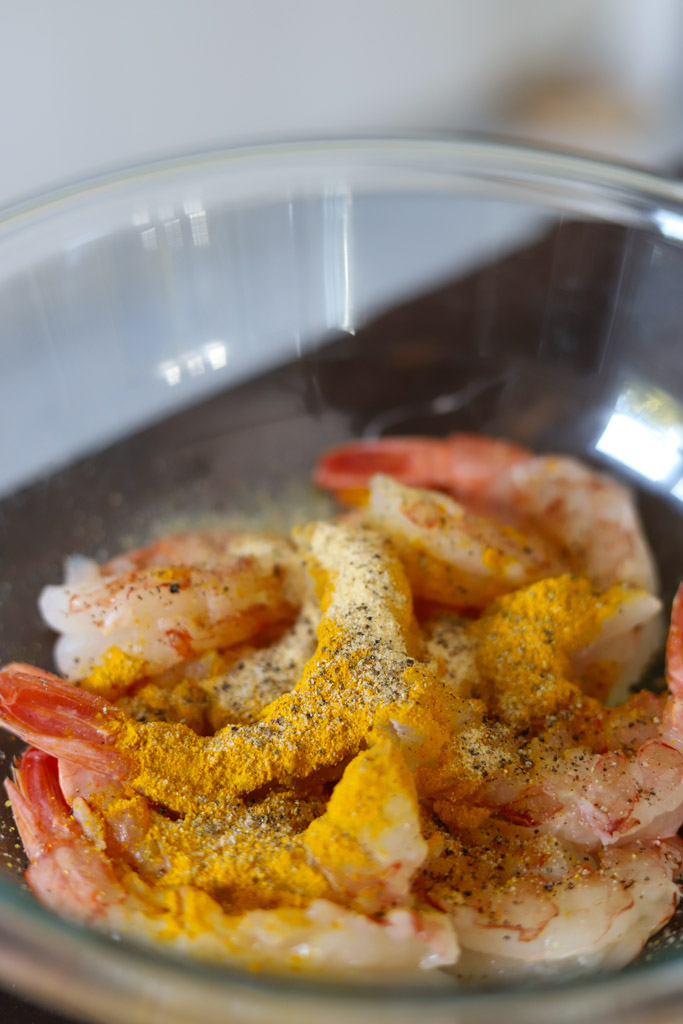 raw shrimp with seasonings in a bowl.