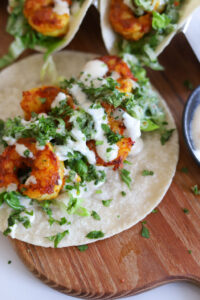 curry shrimp tacos on wooden board.