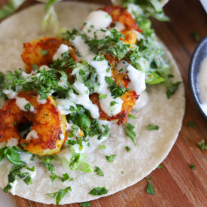 curry shrimp tacos on wooden board.