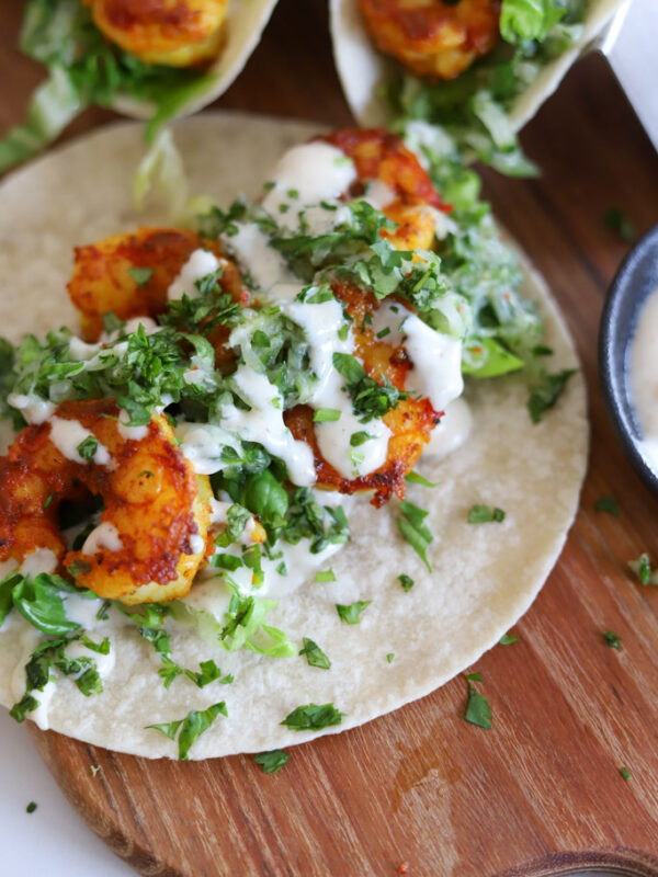 curry shrimp tacos on wooden board.