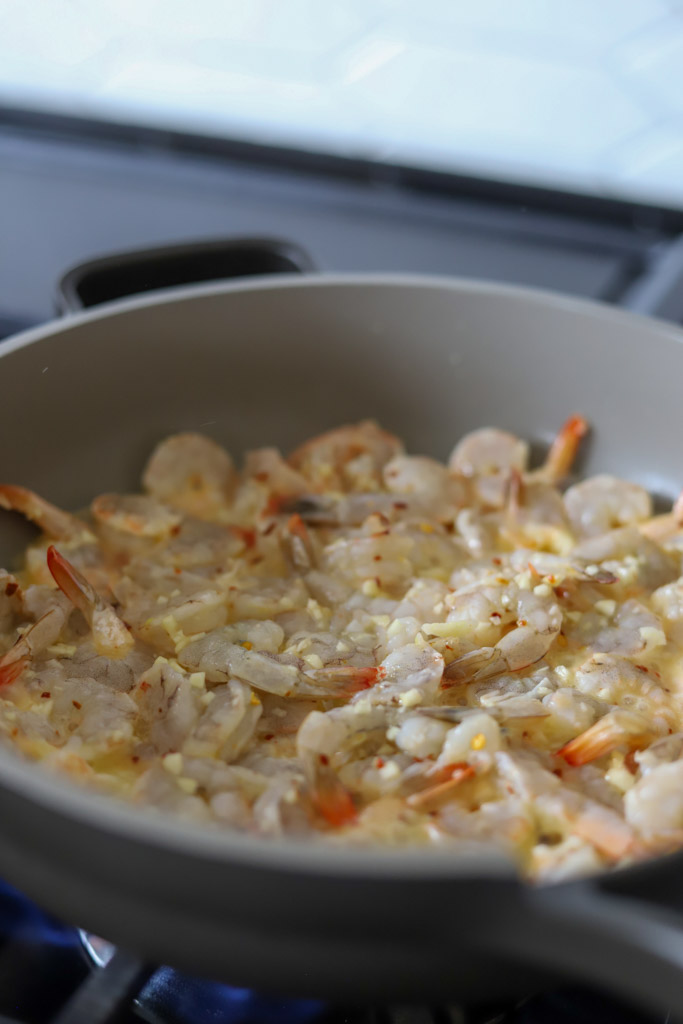 seasoned shrimp cooking in skillet.