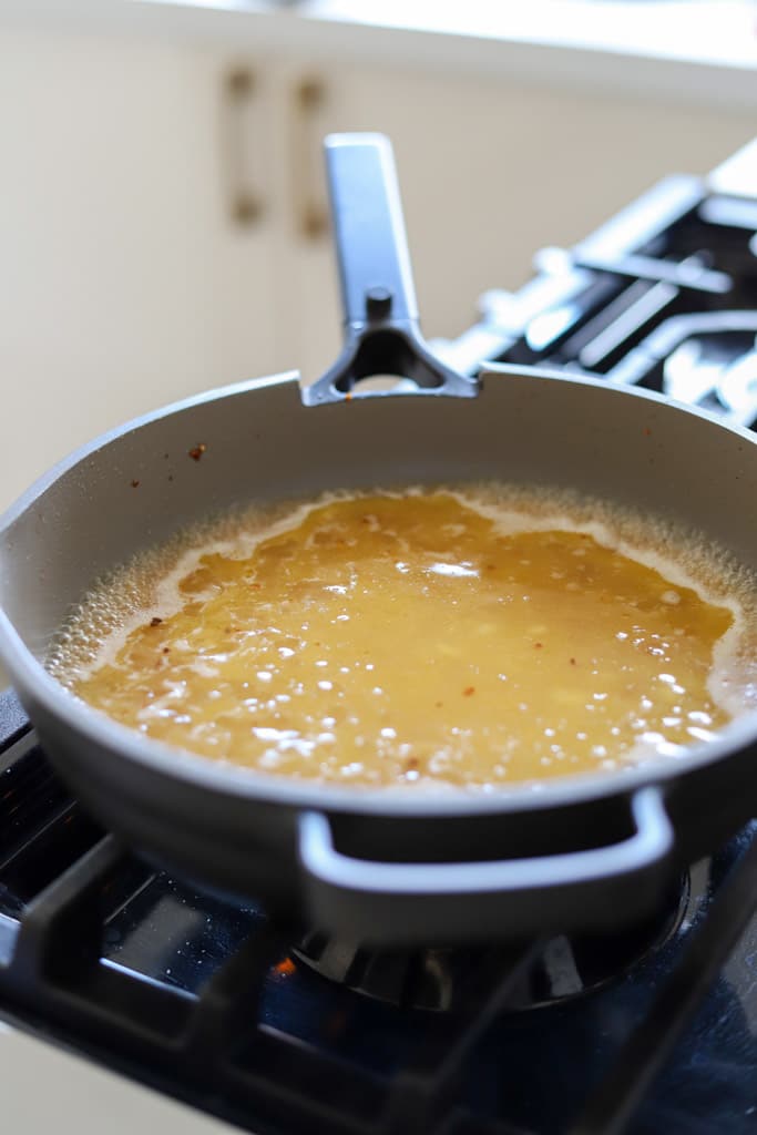 orzo cooking in skillet.