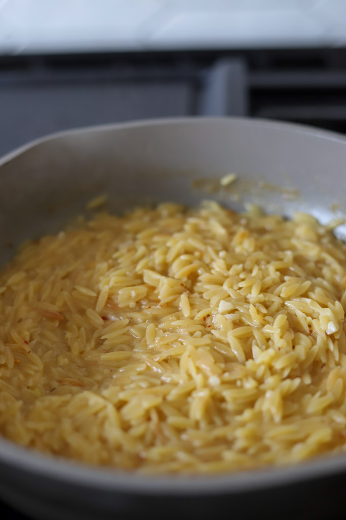 tender orzo pasta in skillet.