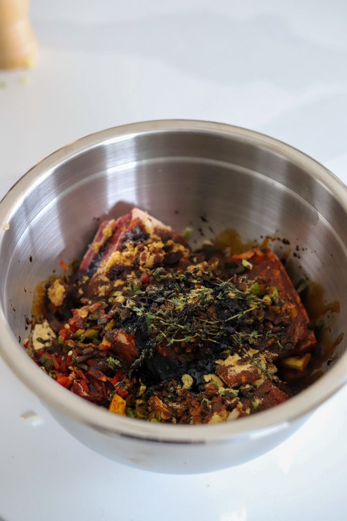 all seasonings in bowl with beef short ribs.