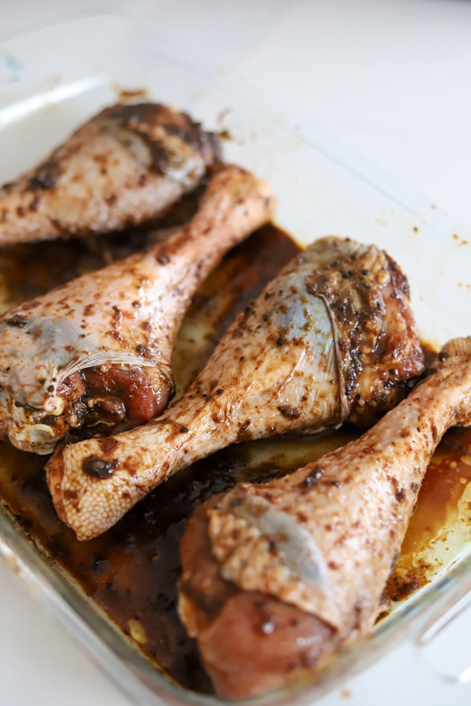 jerk seasoned turkey legs in glass dish.